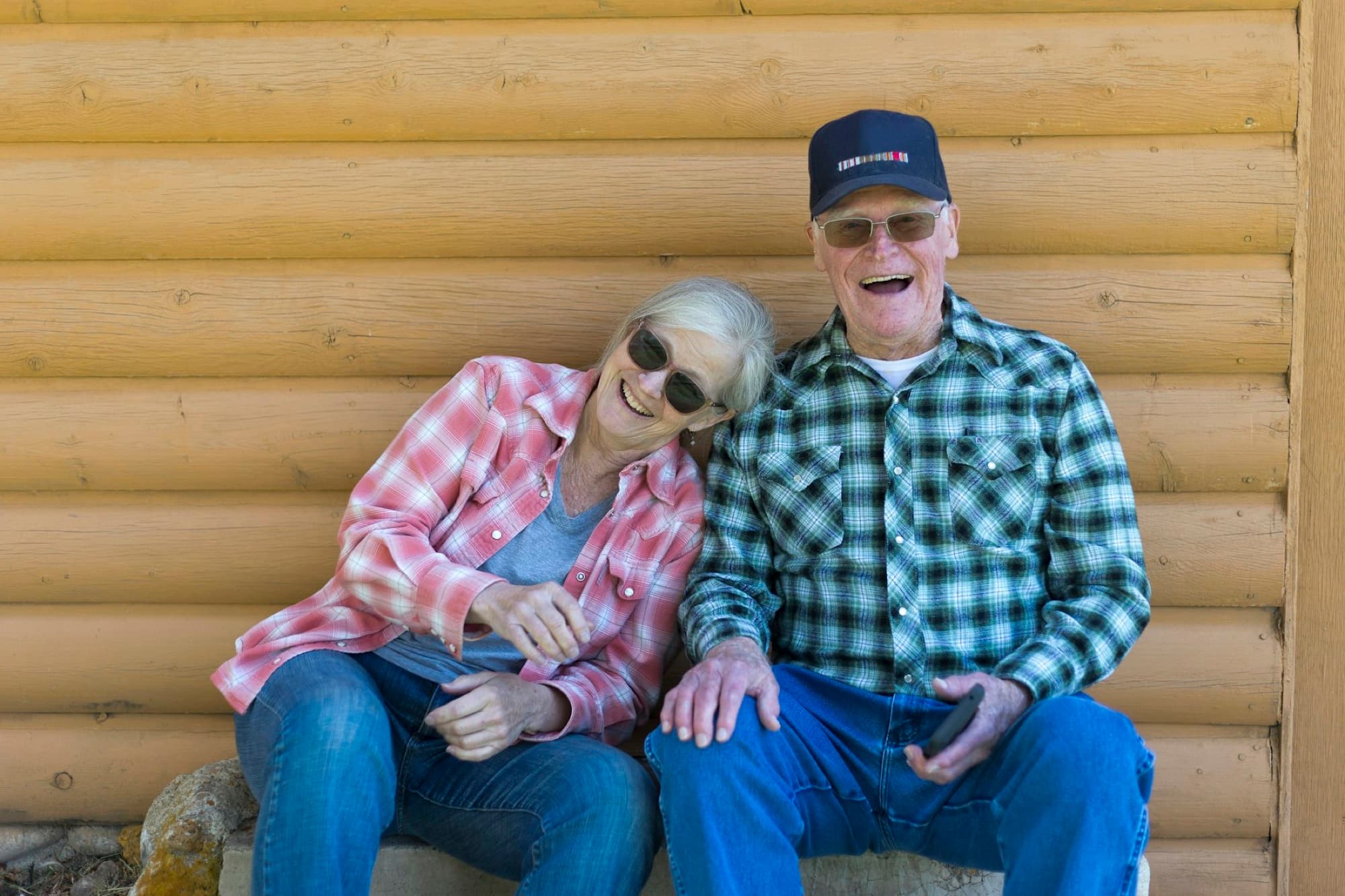 A senior couple laughing on their porch