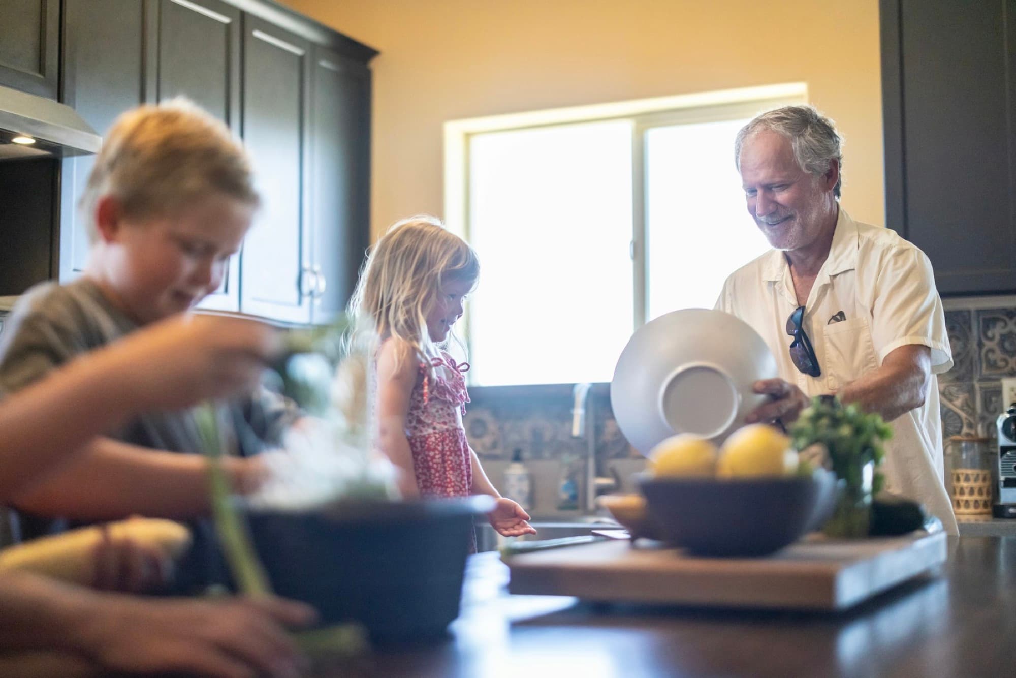 A grandfather cooking with his grandchildren